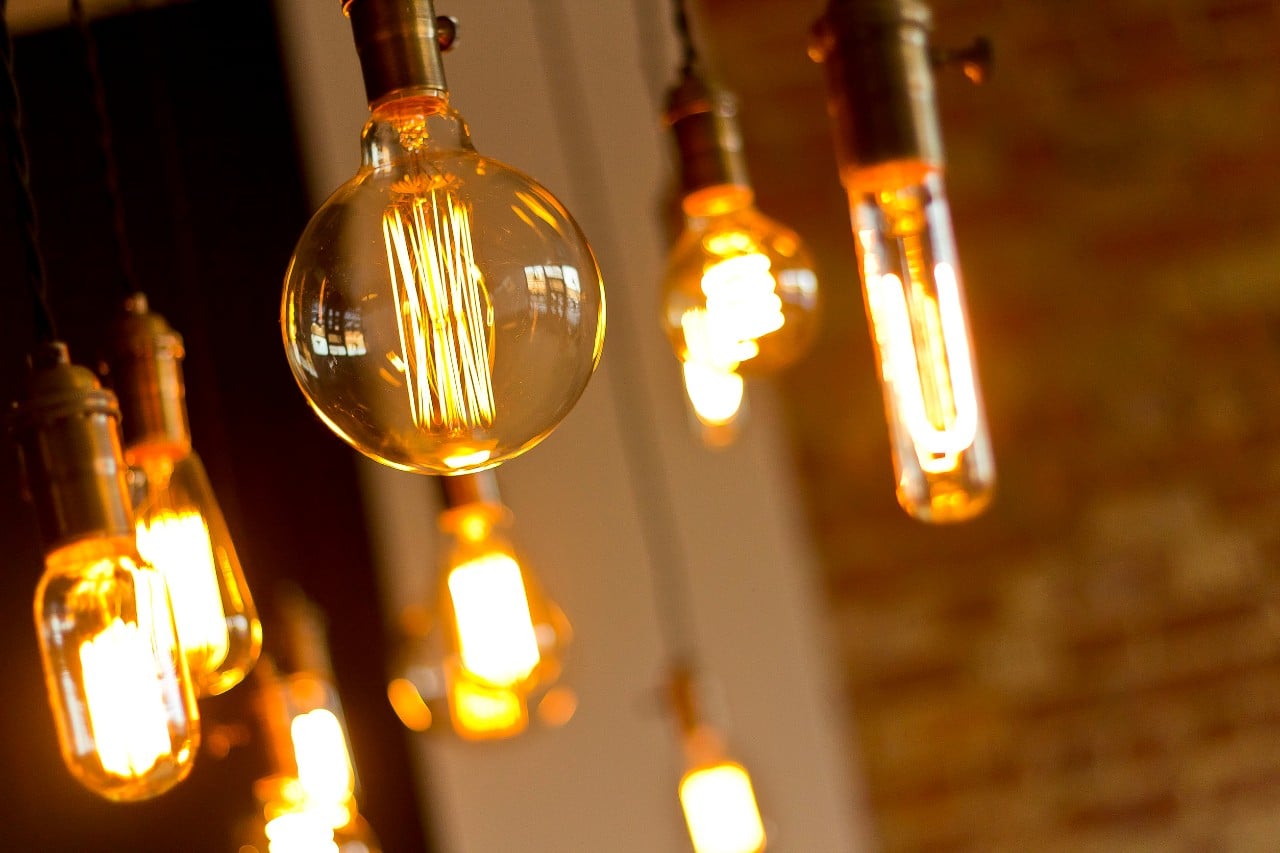 a few old-time edison lightbulbs hang in a warmly lit space; hiring from an expanded talent pool tips