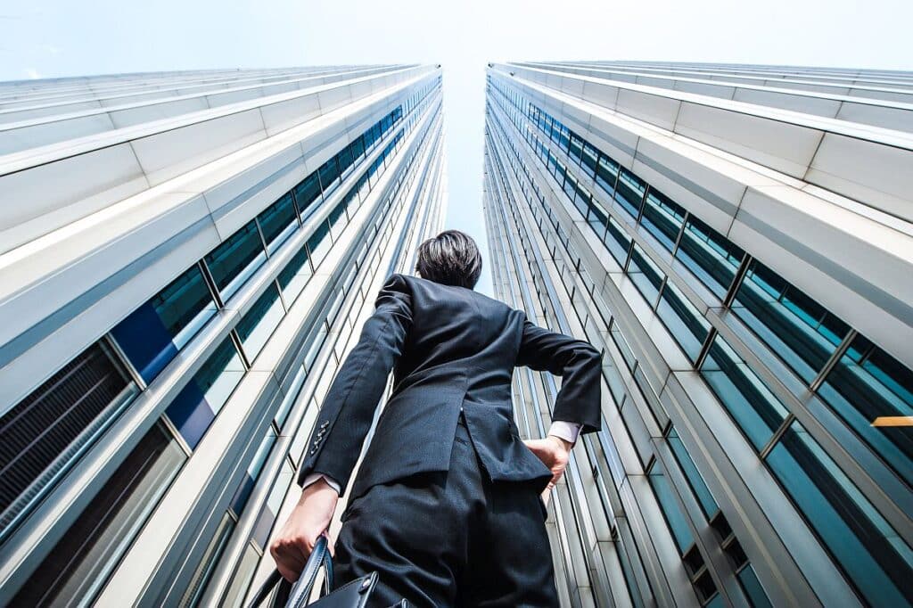 Businessman looking up at the high building, low angle