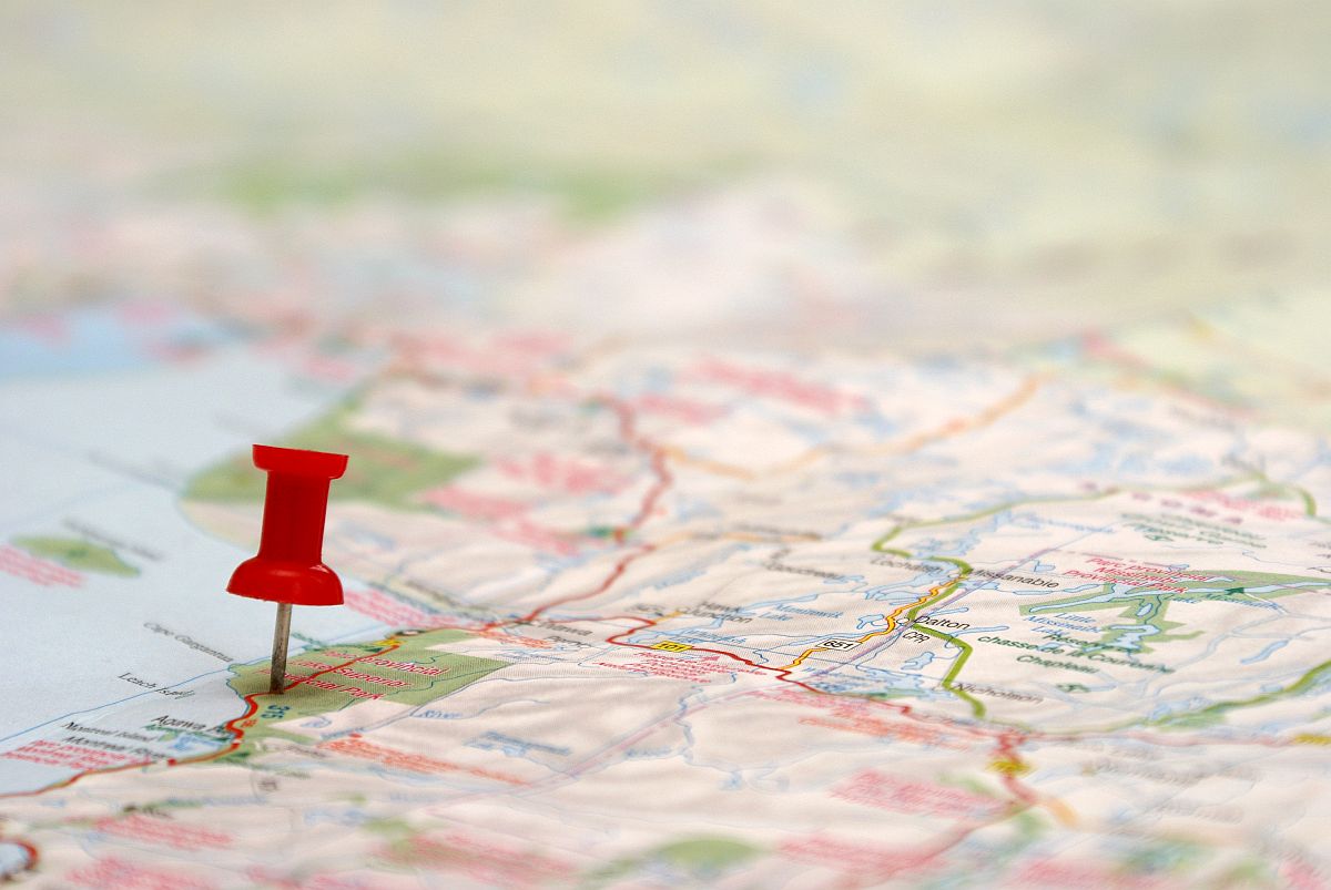 A push pin is inserted on a travel destination of a map; Career Decisions concept