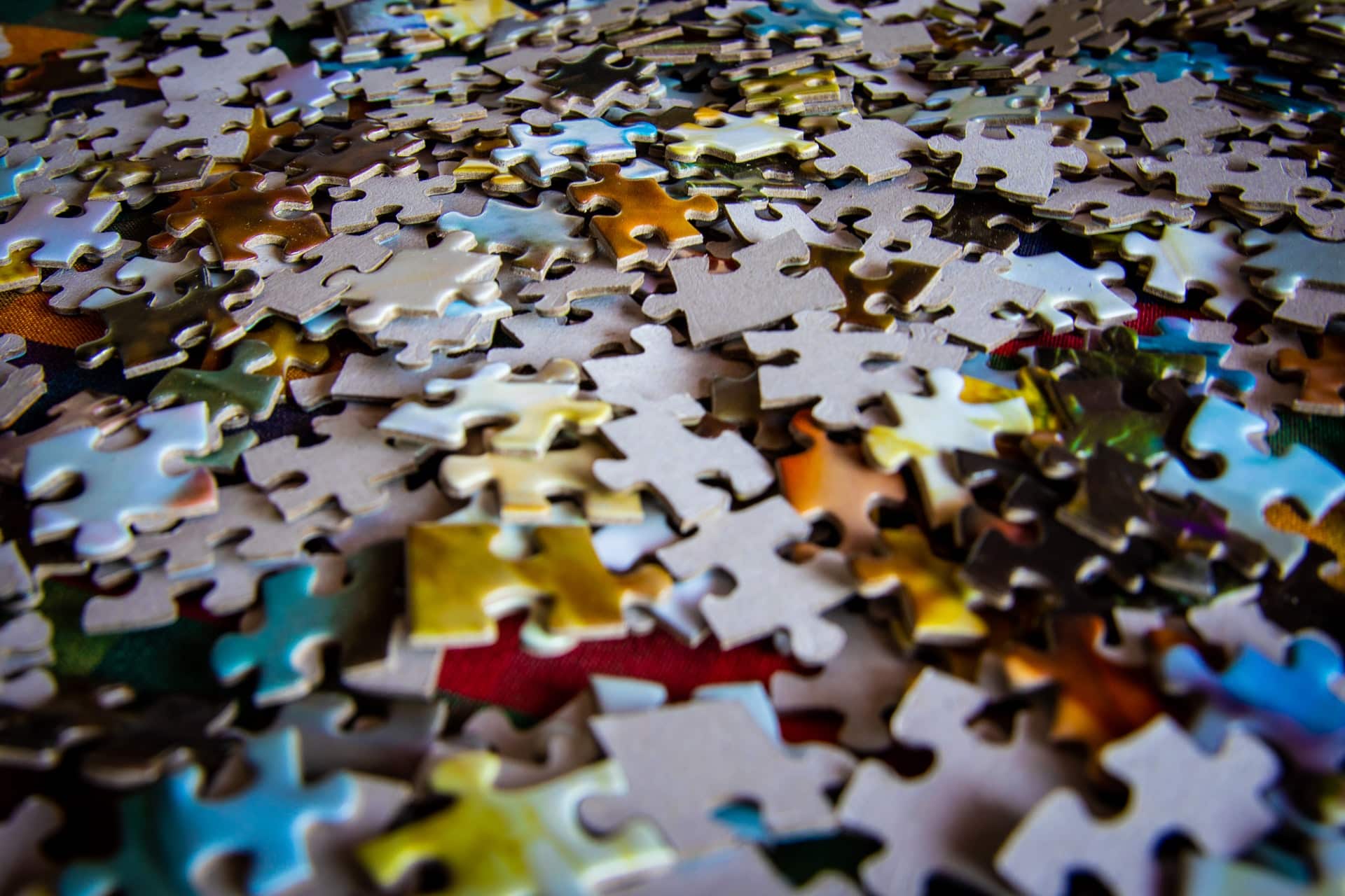 scattered pile of multi-colored puzzle pieces; tech insights and contingent work concept