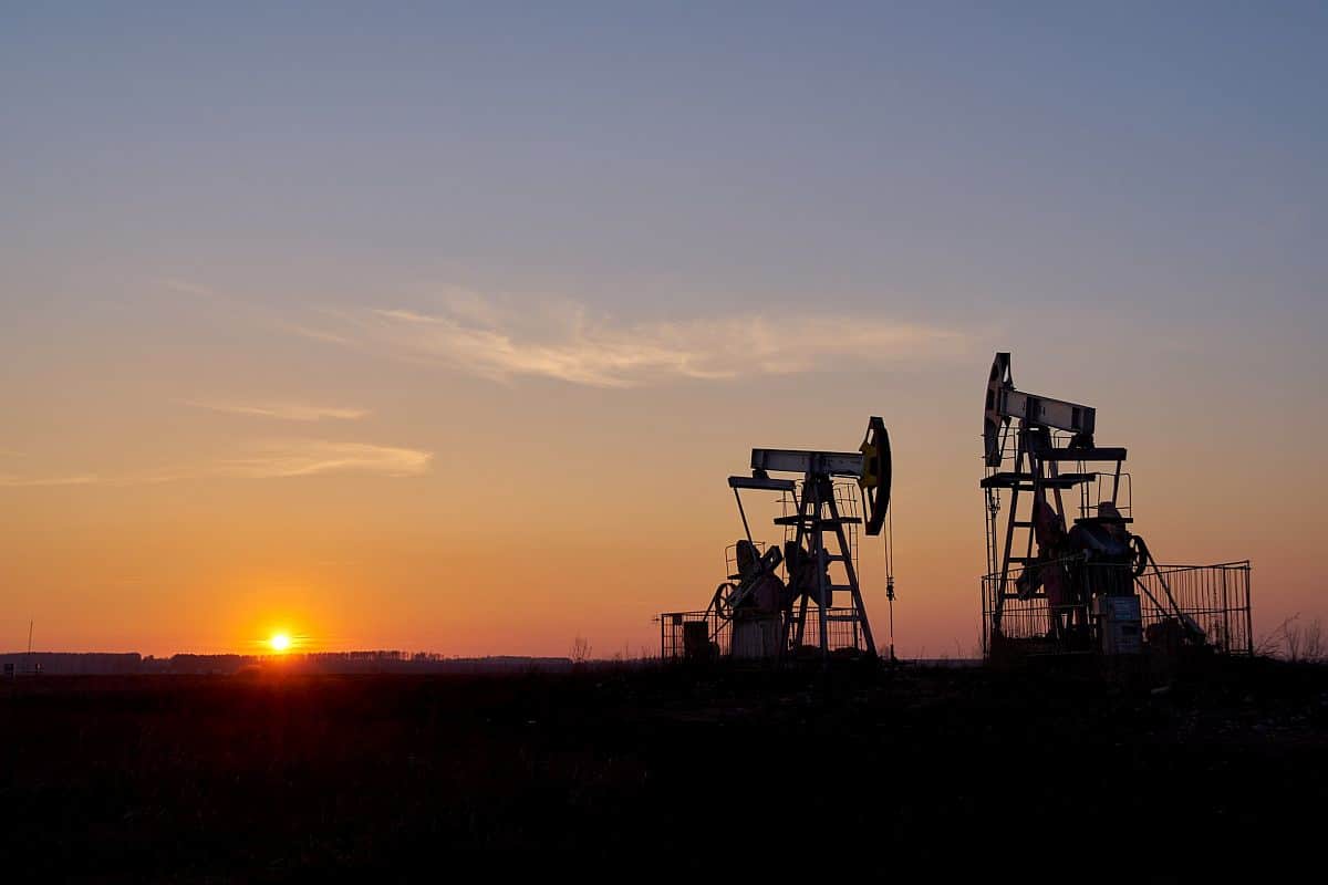 two oil pumping rigs at sunset; hiring in the oil and gas industry concept