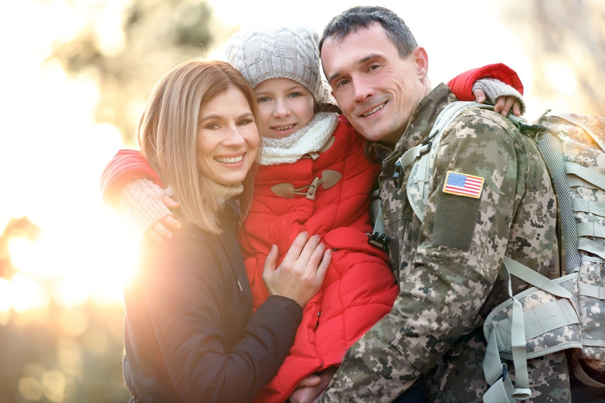 Happy soldier with family in park; army talent management concept